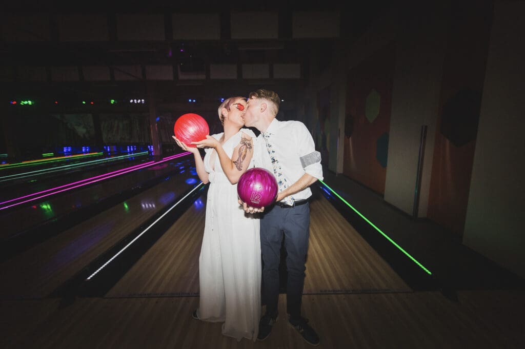 A bride and groom kiss while on the bowling alley at Mammoth Rock N Bowl. 