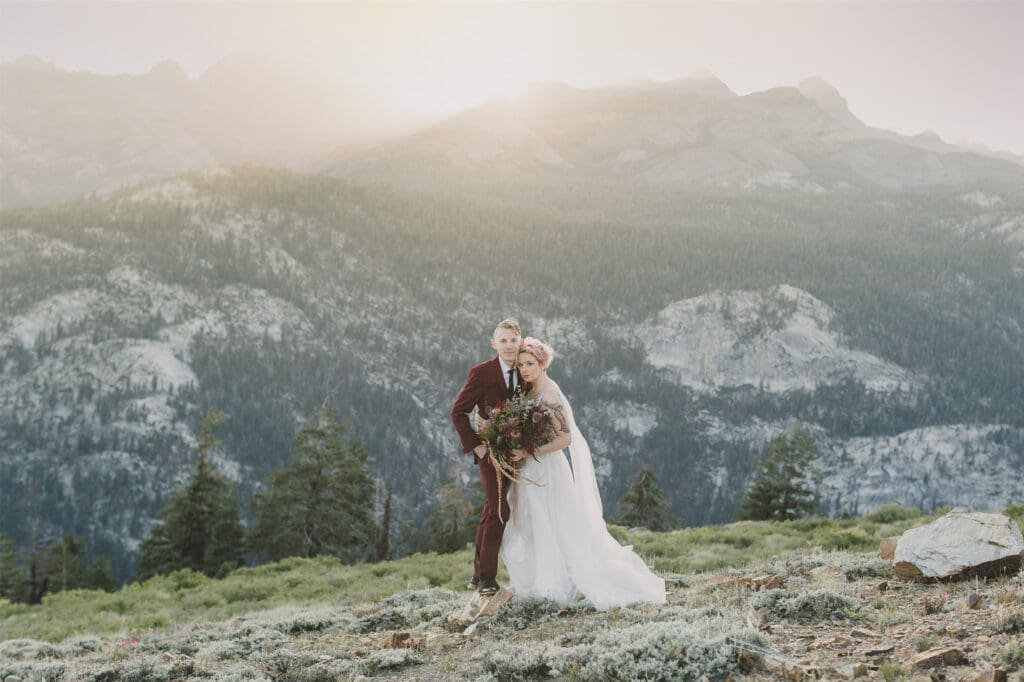 A bride and groom stand in front of a mountain view at their Mammoth lakes Wedding