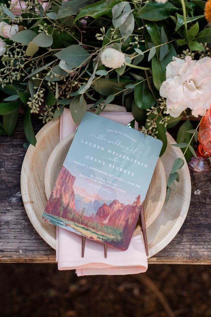 A yosemite themed wedding invitation sit atop a place setting for an outdoor brunch at Yosemite National Park. 