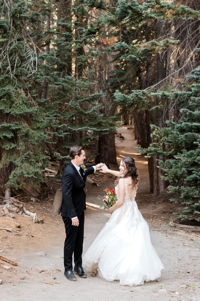 A groom spins his bride on the trail to Taft Point in Yosemite