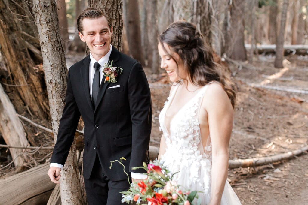 A groom looks at his bride while they walk on the Trail to Taft Point in Yosemite.