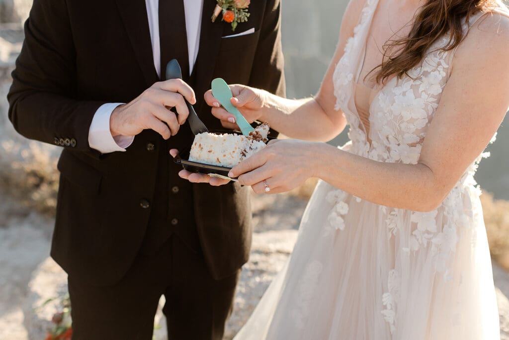 A bride and groom dig in to their favorite grocery store carrot cake with their camping sporks