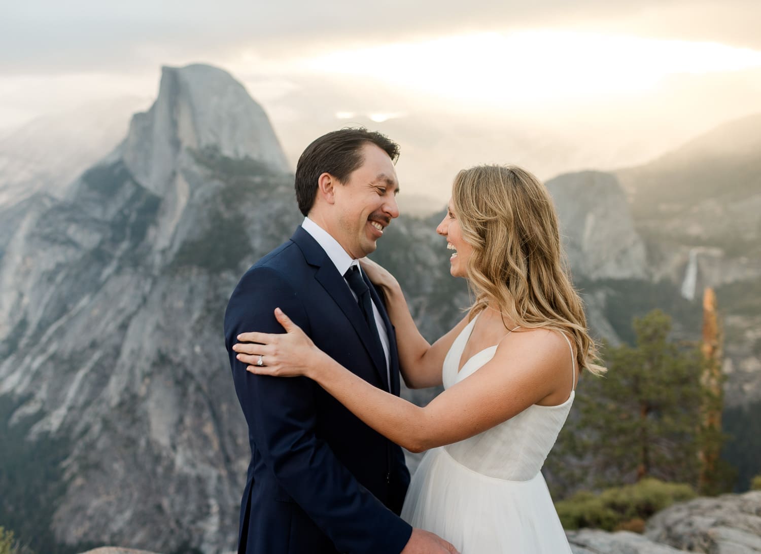 A bride and groom see each other for the first time on their wedding day, in front of Half Dome, in Yosemite National Park.