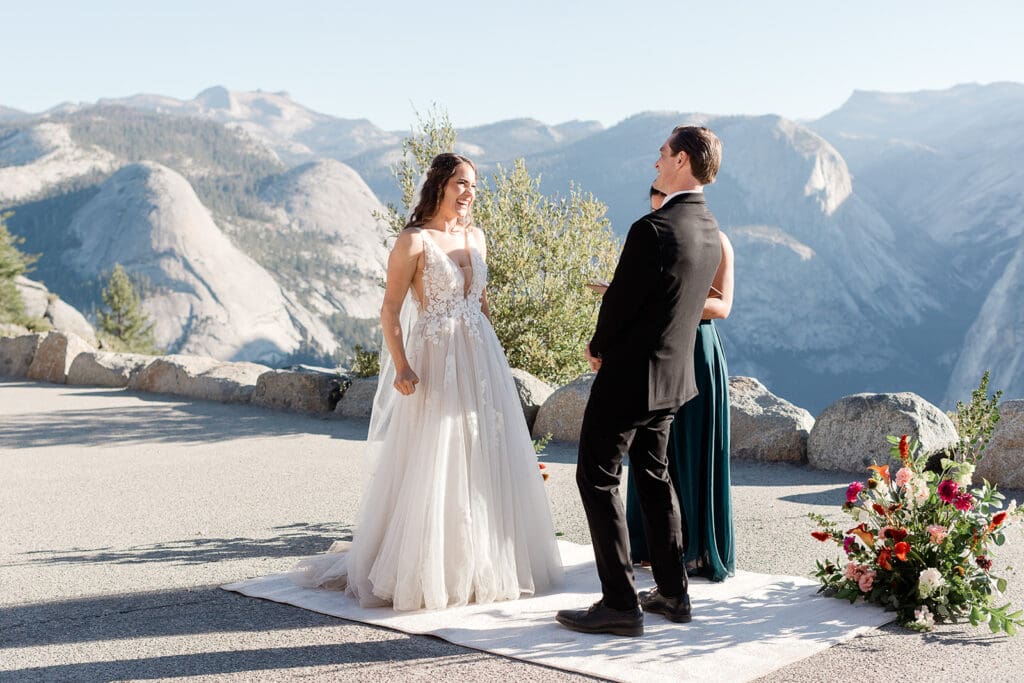 A bride and groom laugh during their wedding ceremony at Glacier Point in Yosemite National Park