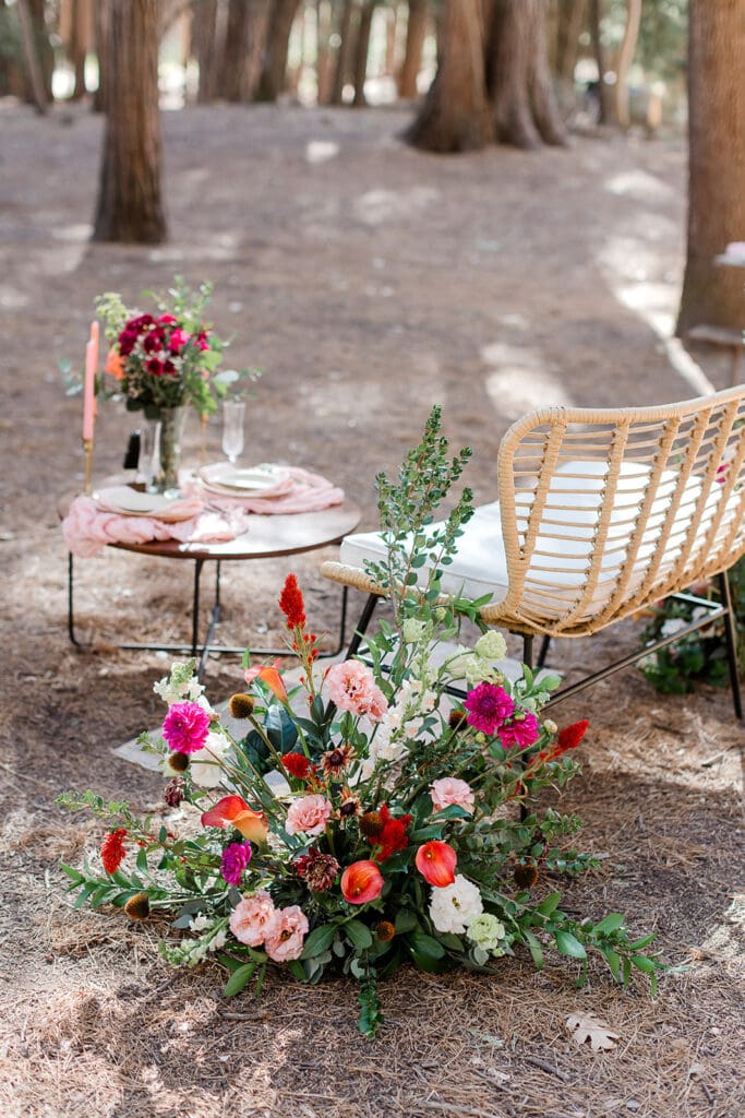 A beautiful floral arrangement next to a table for the bride and groom at their Cathedral Beach brunch in Yosemite National Park