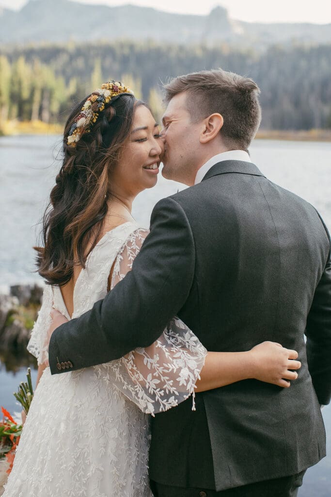 A groom kisses his bride at Twin lakes on their Mammoth Lakes Wedding day.