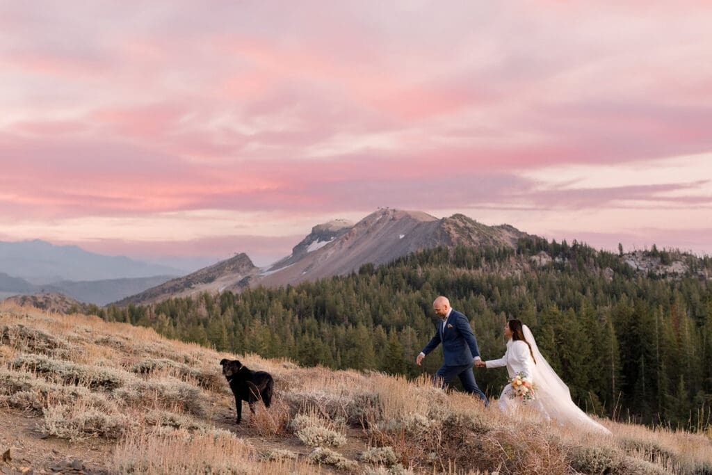 A bride and groom walk at sunset in view of Mammoth Mountain, where they just got married.