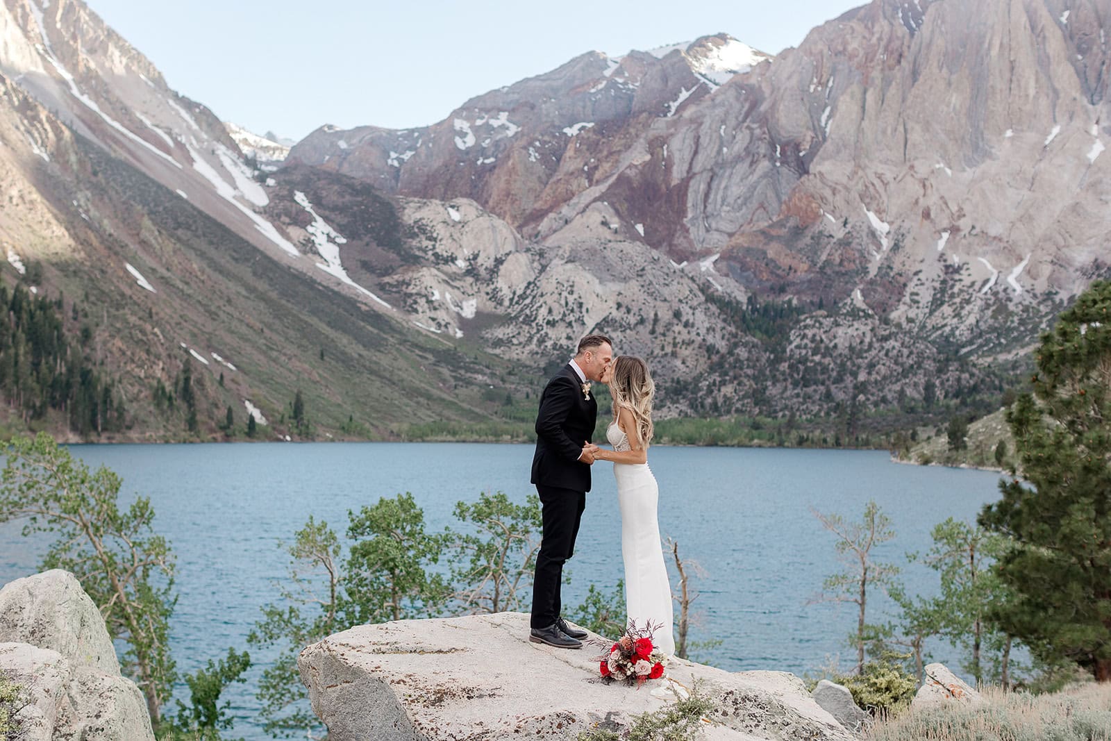 A bride and groom share their first kiss on their wedding day at Convict Lake in Mammoth Lakes.