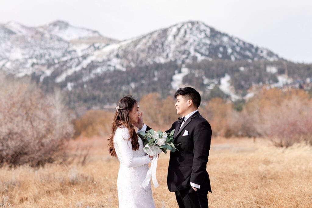 A groom wipes a tear from his bride's face on their Mammoth Lakes Wedding day.