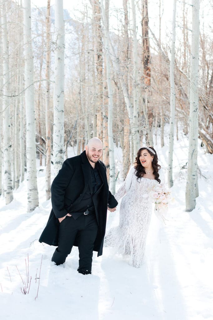 A bride and groom walk in the snow on their Mammoth Lakes Wedding