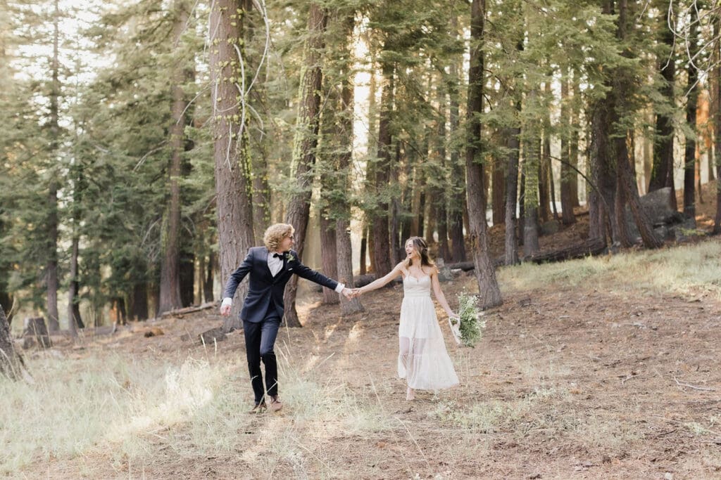 A bride and groom walk through the forest on their Mammoth Lakes Wedding day.