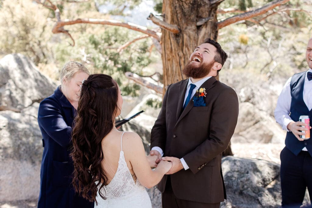 A groom laughs with his bride during their vows at their June Lake wedding