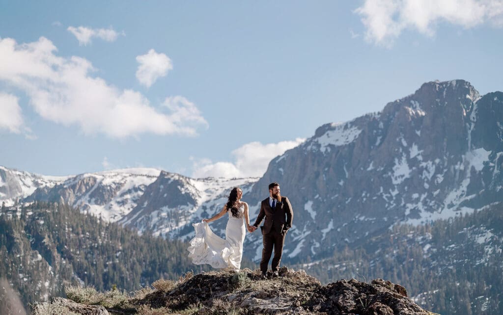 A bride and groom enjoy their windy wedding in front of snow capped mountains in Mammoth Lakes.