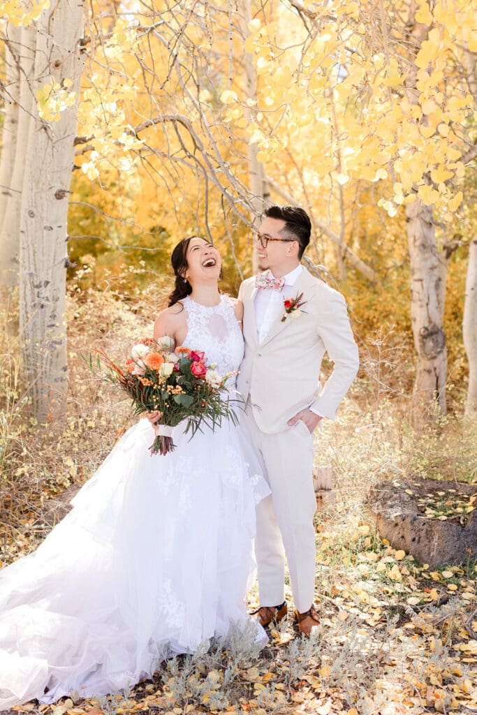 A bride laughs with her groom on a sunny fall day in mammoth lakes.